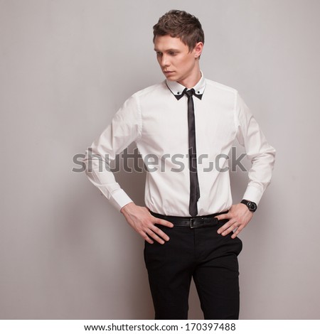 Posing young man model in black and white clothing