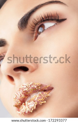 Face with creative lips with little keys makeup