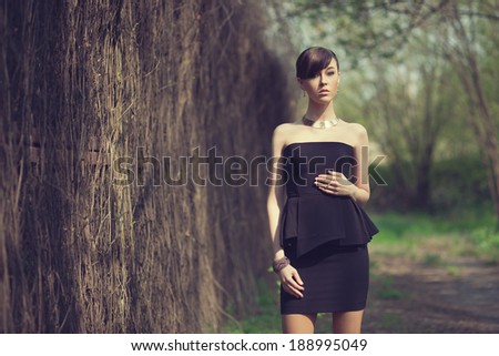 brunette model posing in short black dress