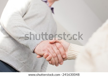 Handshake of adult man and young woman