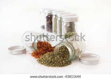 Herbs and spice rack in jars against white backround