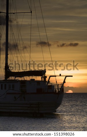 Big sailboat in front of sunset. Sun just falling into ocean. Boca Sami, Curacao, Netherlands Antilles