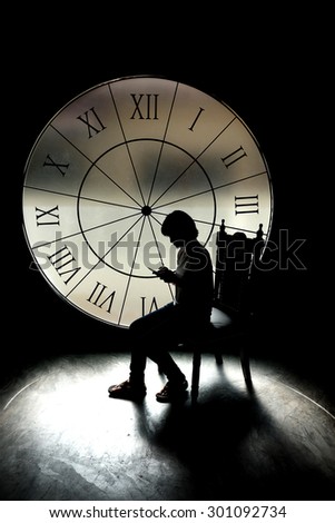 serious girl. thinking about something behind a big clock, silhouette style