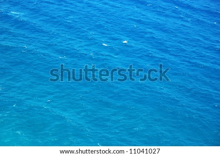sea waves seen 100 meters above and under a bright mid day sun