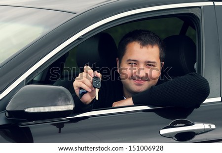 a man driving a car with keys in hand