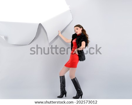 Playful girl in a dress tears off paper