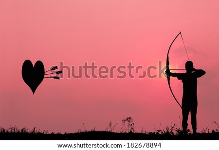 Silhouette archery with a bow shoots the arrows at the heart shape target in the pink sky and cloud.