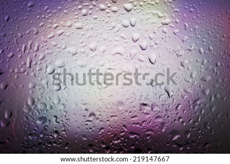 Abstract background water drops on glass with back colorful light.