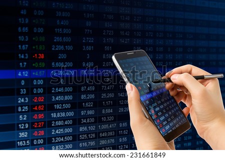 Hand holding smart phone checking financial stats on screen.