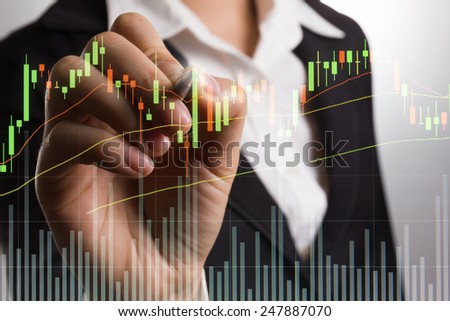 Businessman writing graph for trade stock market on the screen.