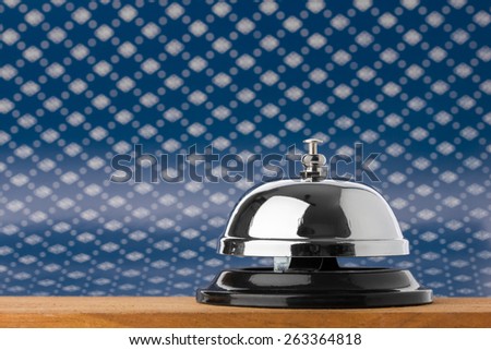 Service bell on wood board with blue background.