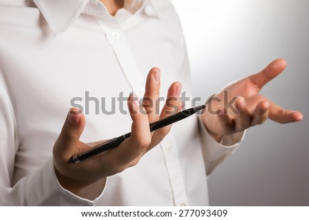 close up of hands gesturing while holding pen, focus on hand holding pen.