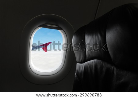 View of the sky and clouds with aircraft wing from the airplane window,empty seats.