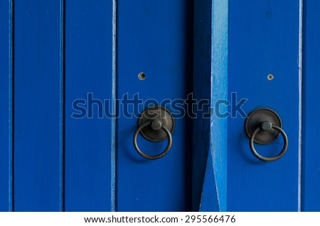 Blue painted wooden door with old bronze handles and locks.