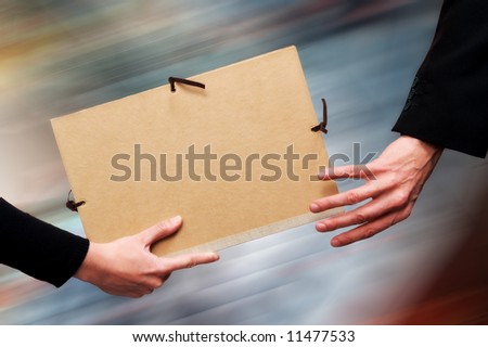 Two persons exchanging a file as a relay baton. Motion blur at the background.