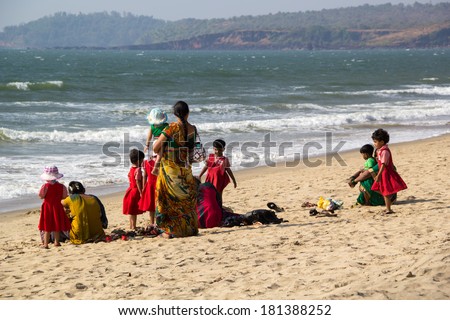 GOA, INDIA - JAN. 10,2014: Indian woman with children relaxing on the beach in Goa, India on JAN. 10, 2014.