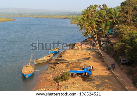 GOA, INDIA, MAR. 15, 2014: Loading works of river sand from boats to truck on the River Tirakol, Goa, India at MAR. 15, 2014