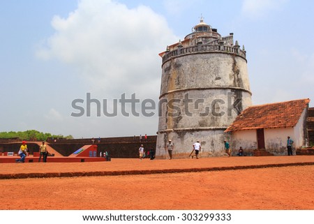 CANDOLIM, GOA, INDIA - 11 APR 2015: Aguada Fort and lighthouse was built in the 17th century. Unknown people rest and play cricket in the fort. A popular place for tourists in Goa.