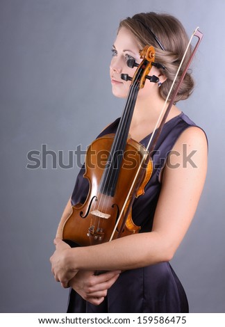 beautiful blue-eyed girl in a dark blue evening dress holding a violin handmade portrait on gray background