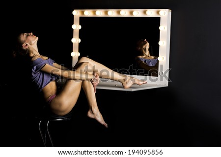 sexy slim girl in front of a mirror in the dark