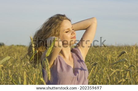 Beautiful blonde in a wheat field. Young girl enjoying the sun. Country style. Country estate. free woman