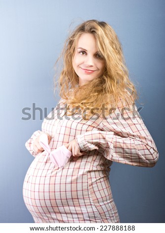 beautiful pregnant blond woman with a big belly at home