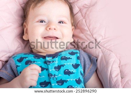Cute baby in a pink bed. Portrait of a baby.Portrait of a smiling child. A child on a white bed. Handsome boy.