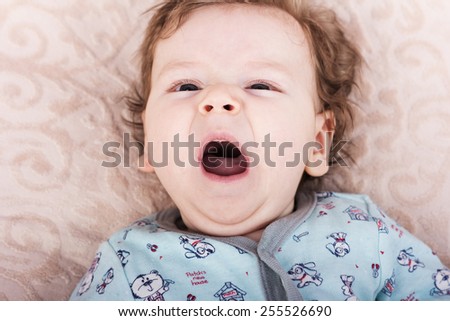 The baby wants to sleep.Beautiful baby.The child in the crib.baby on the bed.Portrait of a smiling child.