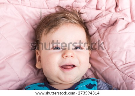 Cute baby in a pink bed. Portrait of a baby.Portrait of a smiling child. A child on a white bed. Handsome boy.