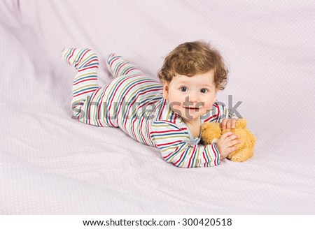 Beautiful baby with a lovely toy. The child in the crib.