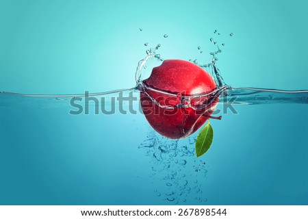 red apple falling into water splach