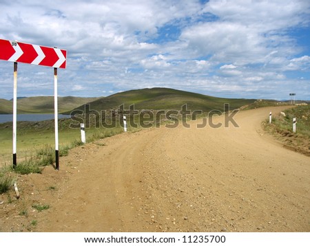 Baikal lake. Olhon island. Yellow brick road with arrow sign.