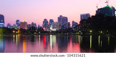 Houses and the lights of the modern city reflected in the water at sunset