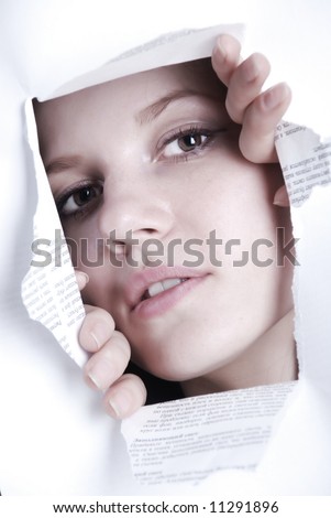 Beauty woman looking through hole in white paper