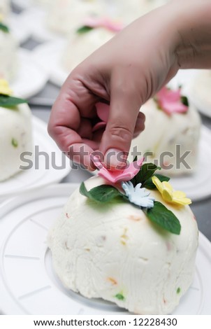 Woman\'s hand made sweet cake with sweet flowers