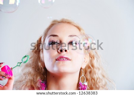 Young woman in pink clothes with soap bubbles