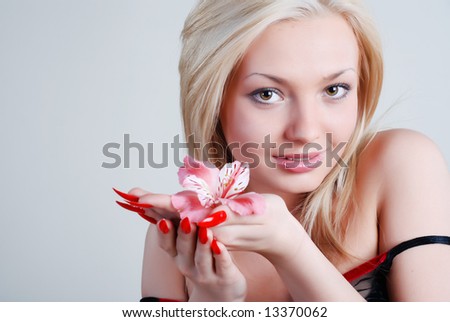The beautiful girl with a flower of an orchid in the left hand