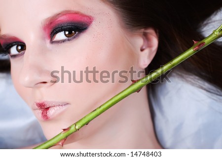 Portrait of beautiful young girl, with the green stem of rose with sharp thorns
