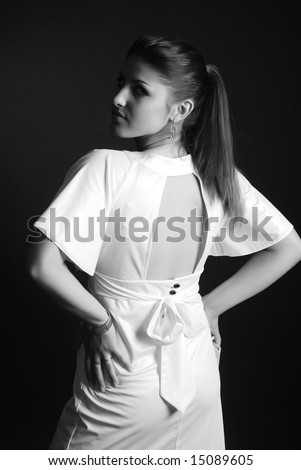 A young beautiful girl is dressed in white clothes at black background