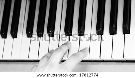 black-and-white picture of keyboard classical musical instrument and human hand