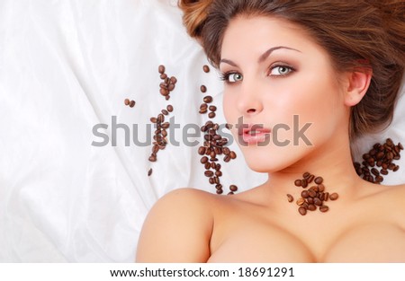 portrait of beautiful young woman with coffee beans around her face