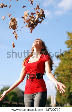 young happy woman in red throw the maple leaf