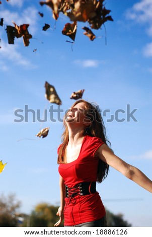 young happy woman in red throw the maple leaf