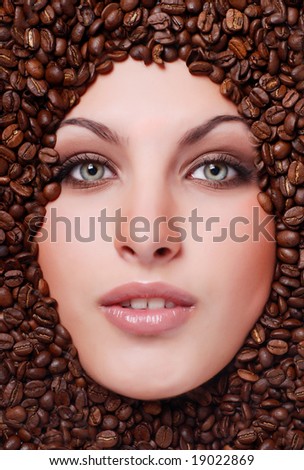 coffee beans around of face beautiful young woman
