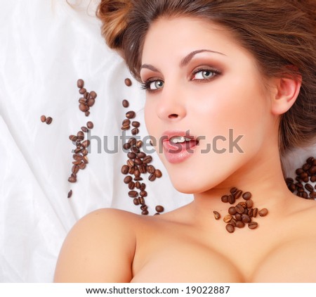 portrait of beautiful young woman with coffee beans around her face