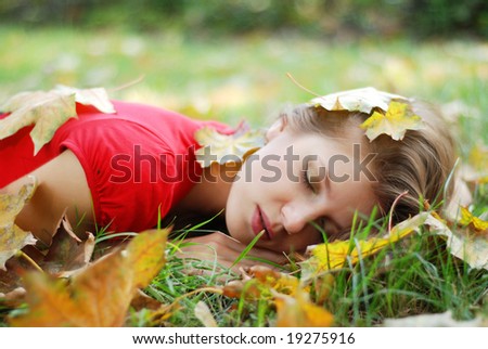 sleeping beauty on the grass with yellow leaves