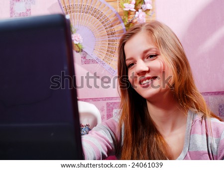 beautiful young woman with laptop at the kitchen