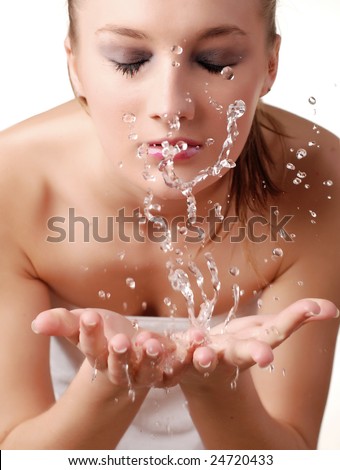beautiful young woman washing her face with water
