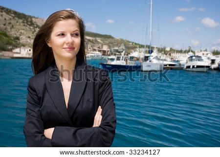 beautiful woman in black suit near the yacht-club