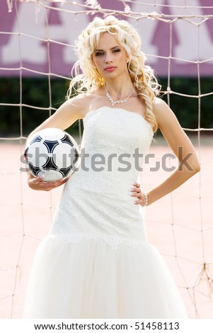 young beautiful bride standing on the gate with ball